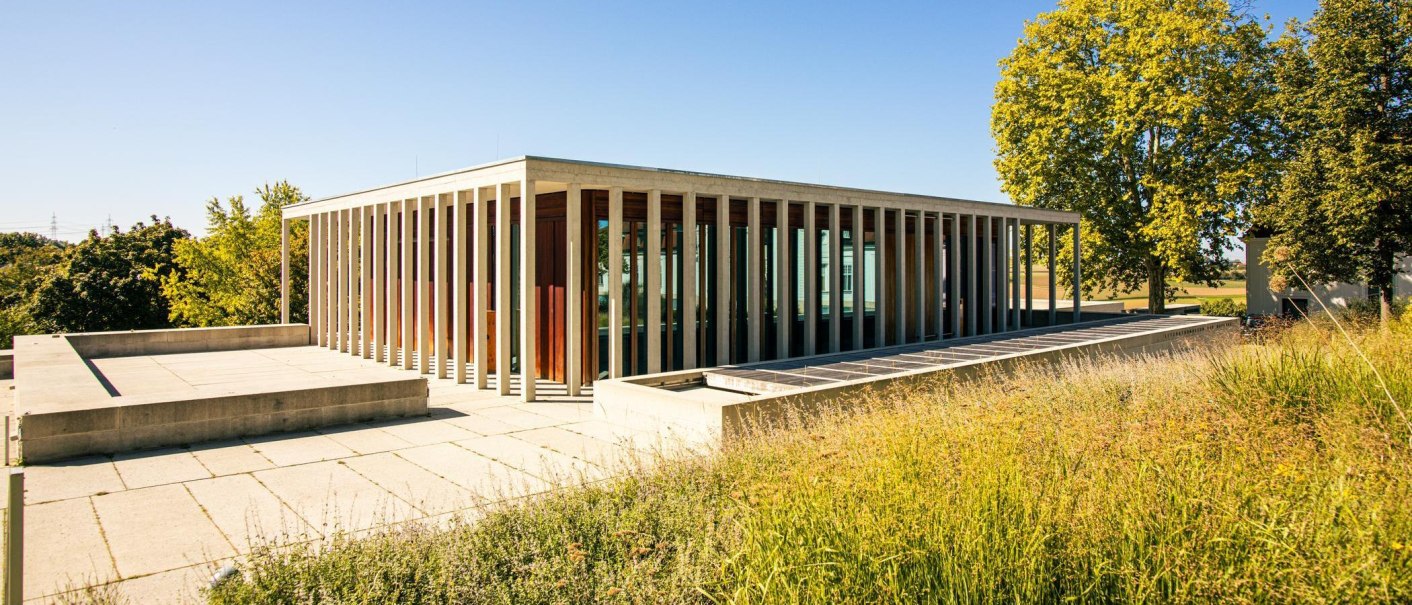 Modernes Literaturmuseum in Marbach am Neckar mit Glasfassade und Säulen, umgeben von grüner Landschaft und Bäumen., © Stuttgart-Marketing GmbH, Sarah Schmid