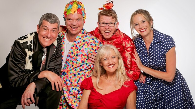 F&uuml;nf Personen in farbenfrohen, ausgefallenen Outfits l&auml;cheln in die Kamera. Die Kleidung ist bunt und kreativ gestaltet., &copy; Theaterhaus Stuttgart e.V.