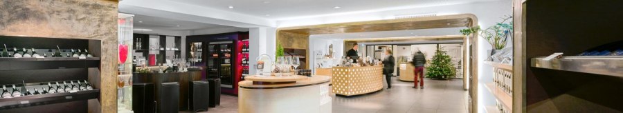 Moderne Vinothek mit eleganter Einrichtung, Weinregalen und einer zentralen Theke. Ein Weihnachtsbaum steht im Hintergrund., © Weinmanufaktur Stuttgart Moderne Vinothek mit eleganter Einrichtung, Weinregalen und einer zentralen Theke. Ein Weihnachtsbaum steht im Hintergrund., © Weinmanufaktur Stuttgart