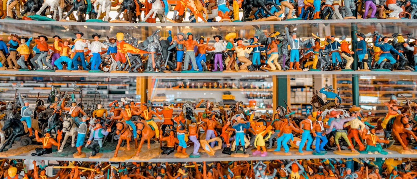Regale voller bunter Spielfiguren in verschiedenen Posen und Outfits, die Szenen darstellen., © Such & Find, Stuttgart