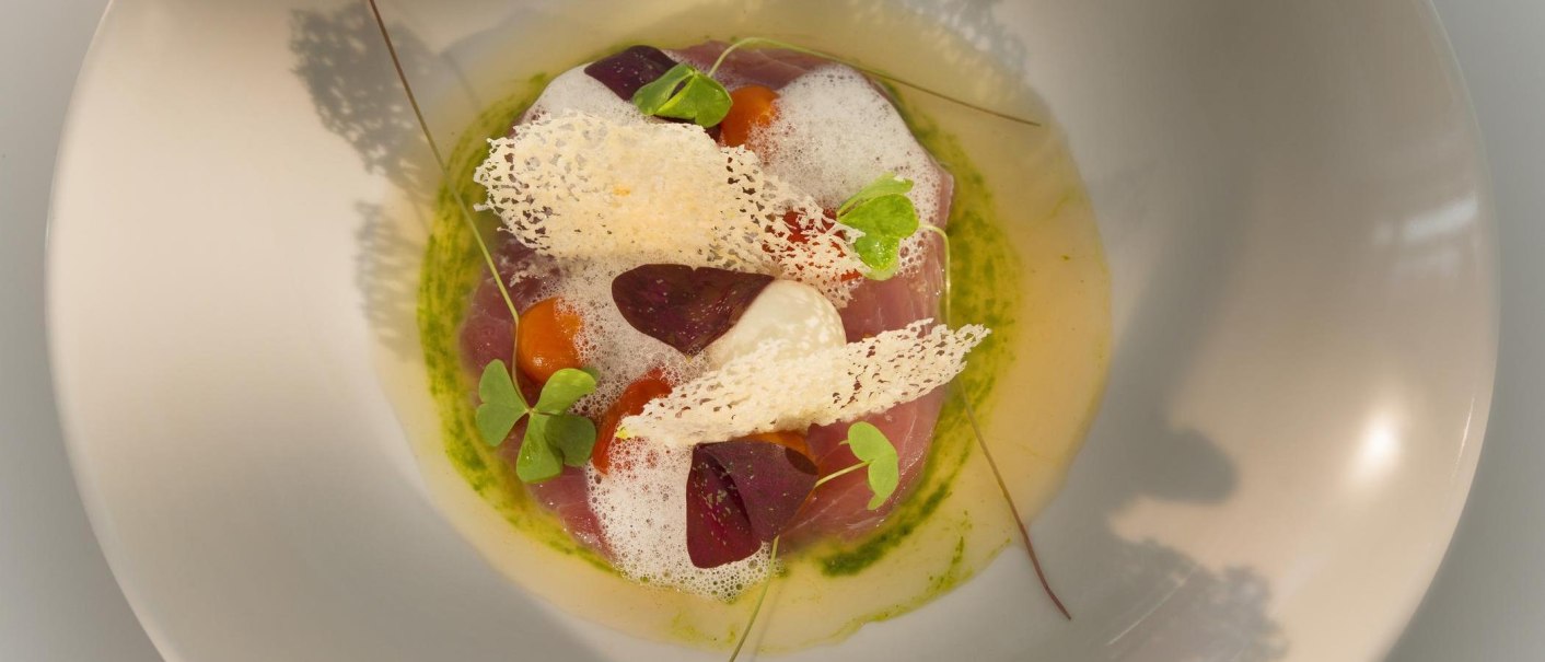 An artfully prepared gourmet dish with foam, herbs and crispy elements on a plate., &copy; Restaurant Bachofer