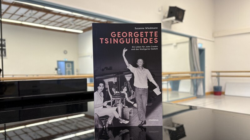 Ein Buch mit dem Titel 'Georgette Tsinguirides' steht auf einem Klavier in einem Tanzstudio mit Spiegeln und Ballettstangen., &copy; W&uuml;rttembergische Staatstheater Stuttgart
