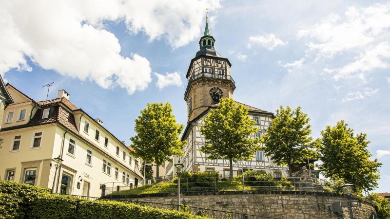 The Backnang town tower rises above half-timbered houses and trees against a blue sky., &copy; SMG Stuttgart Marketing GmbH - Sarah Schmid
