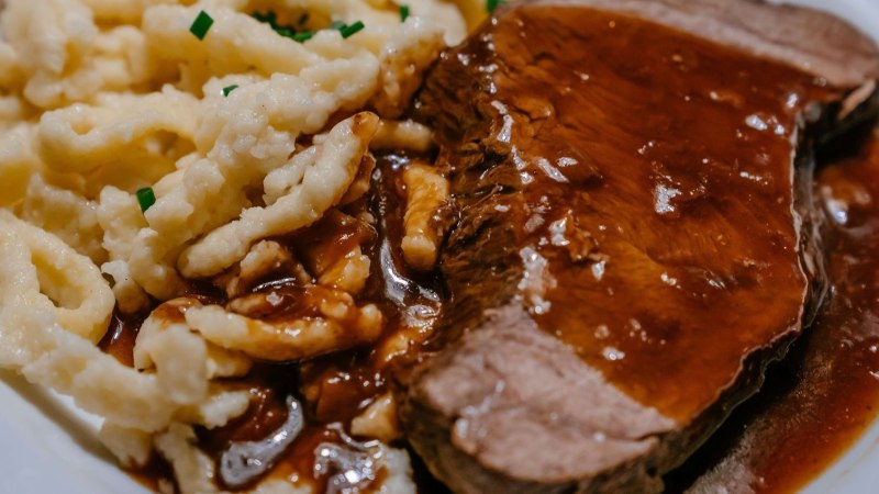 Ein Teller mit Spätzle und einem Stück Braten, übergossen mit dunkler Soße. Die Spätzle sind mit Schnittlauch garniert., © Thomas Niedermüller Ein Teller mit Spätzle und einem Stück Braten, übergossen mit dunkler Soße. Die Spätzle sind mit Schnittlauch garniert., © Thomas Niedermüller