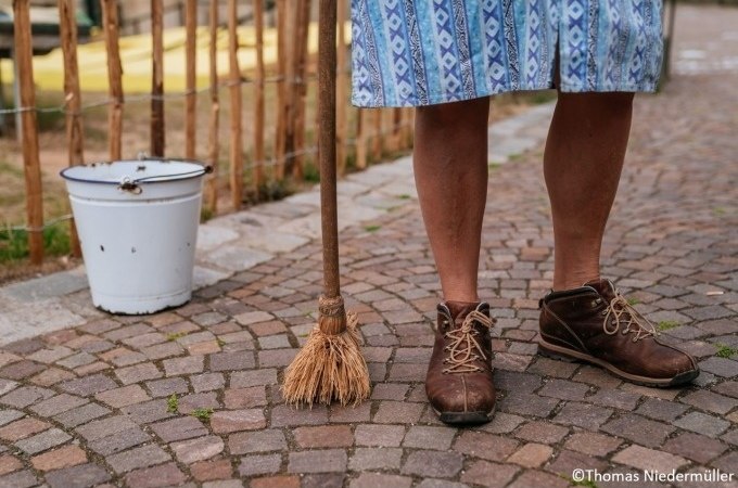 Beine einer Person in braunen Schuhen und blauem Rock stehen auf Kopfsteinpflaster mit Besen und Eimer., &copy; Stuttgart Marketing GmbH, Thomas Niederm&uuml;ller