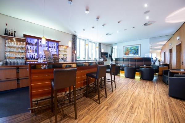 Moderne Hotelbar mit Holzboden, Barhockern und gemütlichem Sitzbereich. Die Bar ist gut beleuchtet und stilvoll eingerichtet., © Kronen Hotel GmbH Moderne Hotelbar mit Holzboden, Barhockern und gemütlichem Sitzbereich. Die Bar ist gut beleuchtet und stilvoll eingerichtet., © Kronen Hotel GmbH