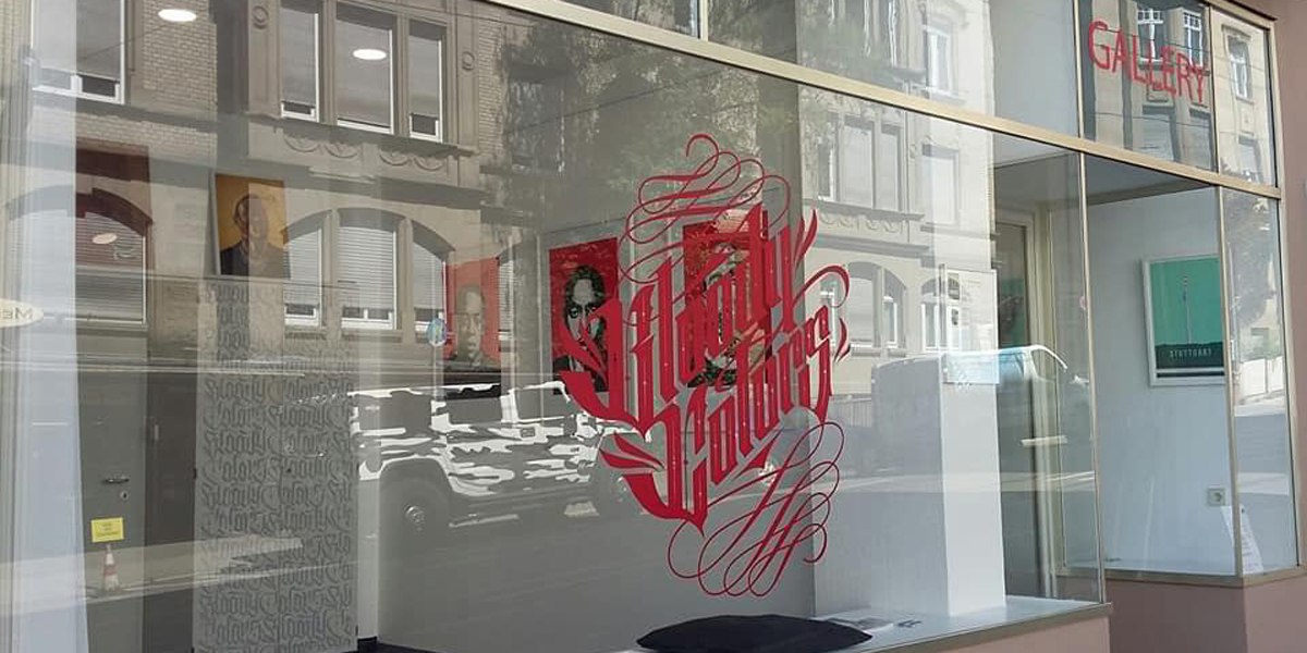 Schaufenster der Bloody Colors Gallery mit rotem Schriftzug und Spiegelung der gegenüberliegenden Gebäude., © Horst Krick Schaufenster der Bloody Colors Gallery mit rotem Schriftzug und Spiegelung der gegenüberliegenden Gebäude., © Horst Krick