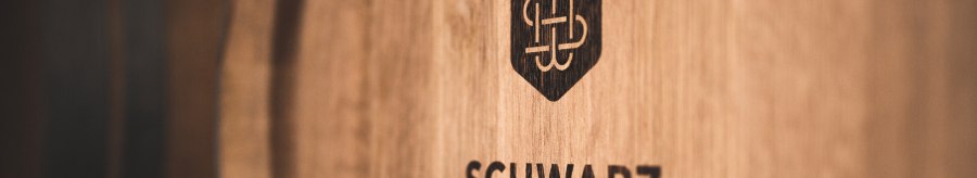 Wooden barrel with the logo and lettering 'Schwarz Weingut', close-up., © Weingut Schwarz