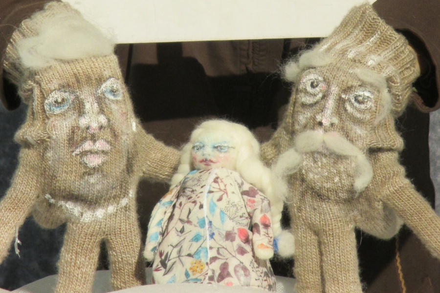 Drei gestrickte Puppen mit weißen Haaren und blauen Augen. Zwei größere Puppen halten eine kleinere Puppe in der Mitte., © Figurentheater Weidringer Drei gestrickte Puppen mit weißen Haaren und blauen Augen. Zwei größere Puppen halten eine kleinere Puppe in der Mitte., © Figurentheater Weidringer