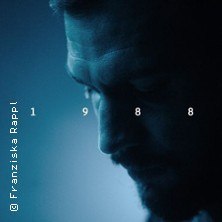 Ein Mann im Profil vor blauem Hintergrund, die Zahl 1988 ist mittig platziert. Foto von Franziska Rappl., © links im Bild