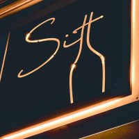 Neonschild mit der Aufschrift 'Sitt' und einer stilisierten Flasche in warmem Licht., © Sitt Wein, Stuttgart Neonschild mit der Aufschrift 'Sitt' und einer stilisierten Flasche in warmem Licht., © Sitt Wein, Stuttgart