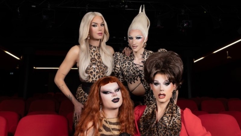 Four people in striking leopard-print clothing sit in a theater with red seats., © Renitenztheater Stuttgart e.V. Four people in striking leopard-print clothing sit in a theater with red seats., © Renitenztheater Stuttgart e.V.