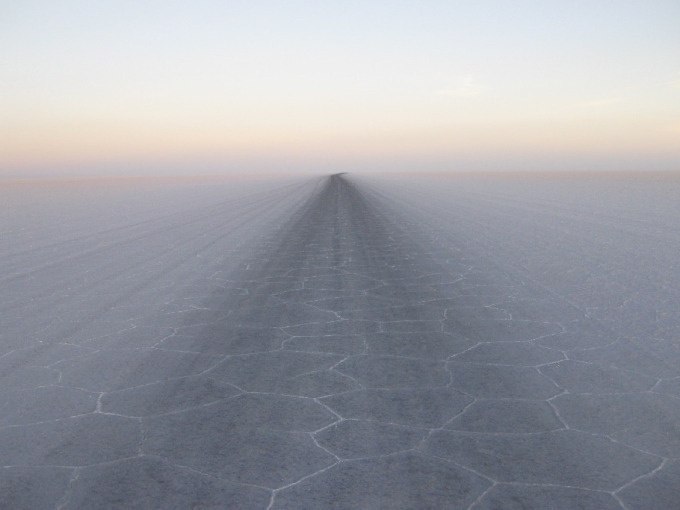 A wide salt plain with hexagonal patterns stretches to the horizon under a clear sky., &copy; Landesmuseum W&uuml;rttemberg