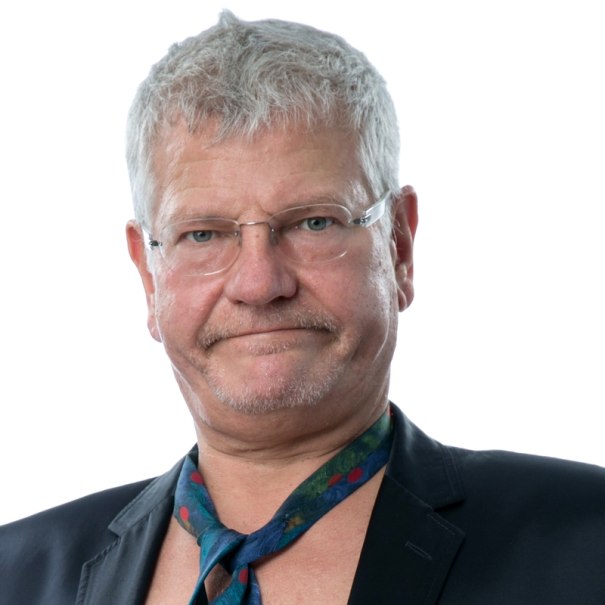 Ein Mann mit grauen Haaren und Brille tr&auml;gt einen Anzug und eine bunte Krawatte. Der Hintergrund ist wei&szlig;., &copy; Renitenztheater Stuttgart e.V.