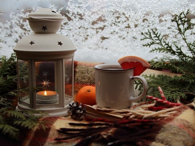 Lantern with candle, cup of tea with grapefruit, orange and fir branches on a blanket in front of an icy window., &copy; Cool-Tours StattReisen