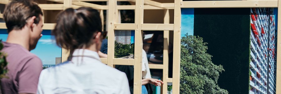 Two people look at an installation of wooden frames with photos of buildings and landscapes., &copy; &copy; St&auml;dtisches Lapidarium, Foto Julia Ochs