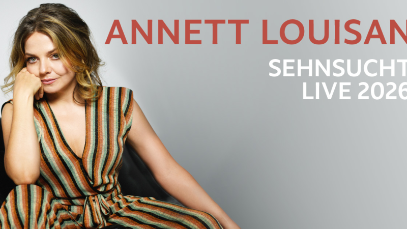 Eine Frau in einem gestreiften Kleid sitzt entspannt auf einem Sofa. Daneben steht der Text 'Annett Louisan Sehnsucht Live 2026'., &copy; links im Bild