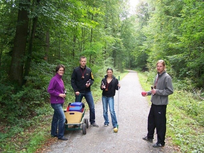Vier Personen stehen auf einem Waldweg. Sie haben einen Bollerwagen und Getr&auml;nke dabei, vermutlich beim Bo&szlig;eln., &copy; Cool-Tours StattReisen