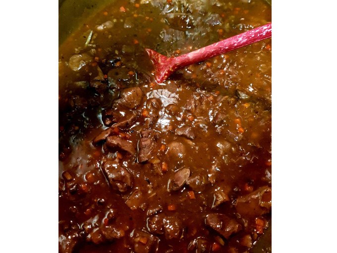 Game ragout in dark sauce with a red cooking spoon, taken during a cooking course., © Kultweine-Kochwelten-Kunstücke - Kochschule Sonja Lenz Game ragout in dark sauce with a red cooking spoon, taken during a cooking course., © Kultweine-Kochwelten-Kunstücke - Kochschule Sonja Lenz