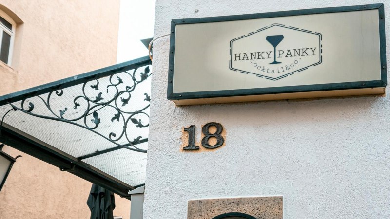 Ein Schild mit der Aufschrift 'Hanky Panky Cocktail & co' h&auml;ngt an einer Hauswand mit der Nummer 18. Eine Laterne und ein dekoratives Vordach sind sichtbar., &copy; Stuttgart-Marketing GmbH, Sarah Schmid