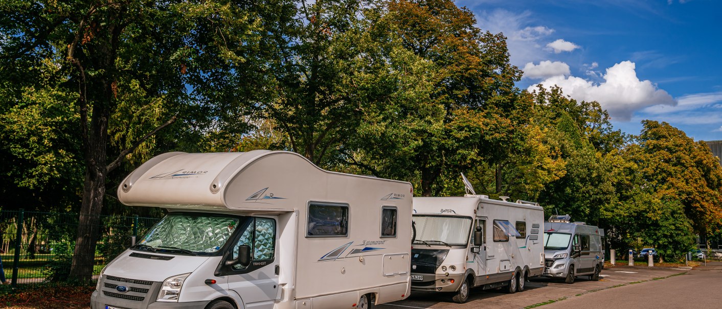 Wohnmobile parken auf einem Stellplatz in Ludwigsburg, umgeben von grünen Bäumen und blauem Himmel., © Stuttgart-Marketing GmbH, Thomas Niedermüller Wohnmobile parken auf einem Stellplatz in Ludwigsburg, umgeben von grünen Bäumen und blauem Himmel., © Stuttgart-Marketing GmbH, Thomas Niedermüller