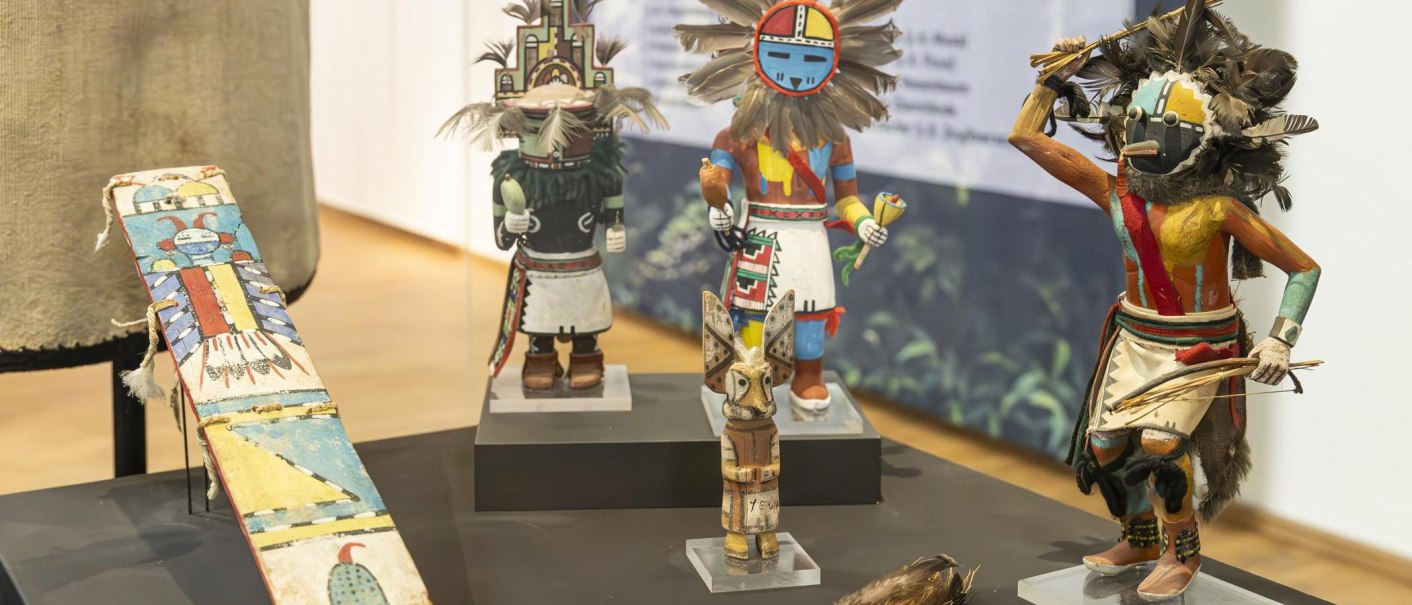 Traditionelle, bunte Figuren und Masken ausgestellt im Linden-Museum Stuttgart, auf einem Tisch arrangiert., © Stuttgart-Marketing GmbH, Sarah Schmid