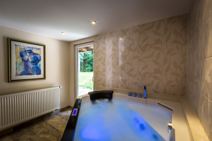 A whirlpool in a room with a work of art on the wall, tile flooring, and a view of a garden., &copy; Kulinarium an der Glems