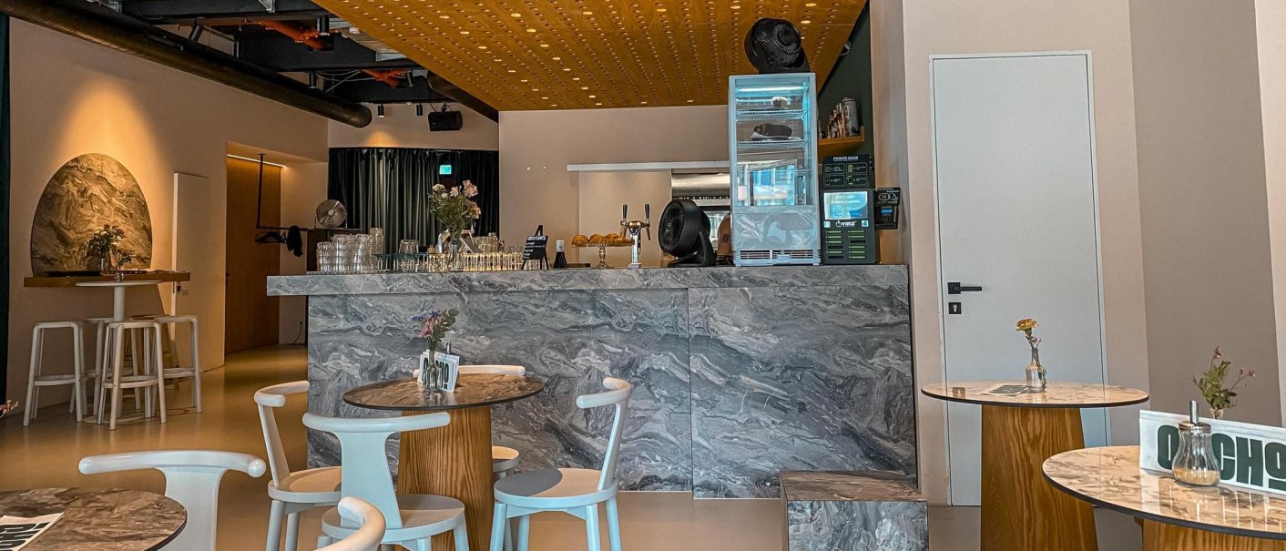 Modernes Café mit Marmortischen und einer stilvollen Theke. Dezente Beleuchtung und minimalistische Dekoration schaffen eine einladende Atmosphäre., © SMG Modernes Café mit Marmortischen und einer stilvollen Theke. Dezente Beleuchtung und minimalistische Dekoration schaffen eine einladende Atmosphäre., © SMG