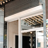Eingang eines Caf&eacute;s mit der Aufschrift 'ConSafos Caf&eacute; & Bar' auf der Glast&uuml;r. Daneben eine Wand mit Aufklebern., &copy; SMG Stuttgart Marketing GmbH - Sarah Schmid