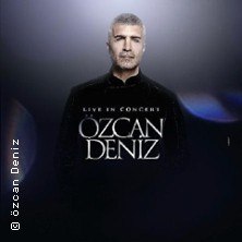 Ein Mann in schwarzer Kleidung steht vor einem dunklen Hintergrund. Der Text 'Live in Concert &Ouml;zcan Deniz' ist prominent zu sehen., &copy; links im Bild