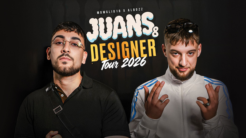 Zwei M&auml;nner posieren vor einem Poster f&uuml;r die 'Juans & Designer Tour 2026'. Einer tr&auml;gt eine Brille, der andere eine wei&szlig;e Jacke., &copy; links im Bild