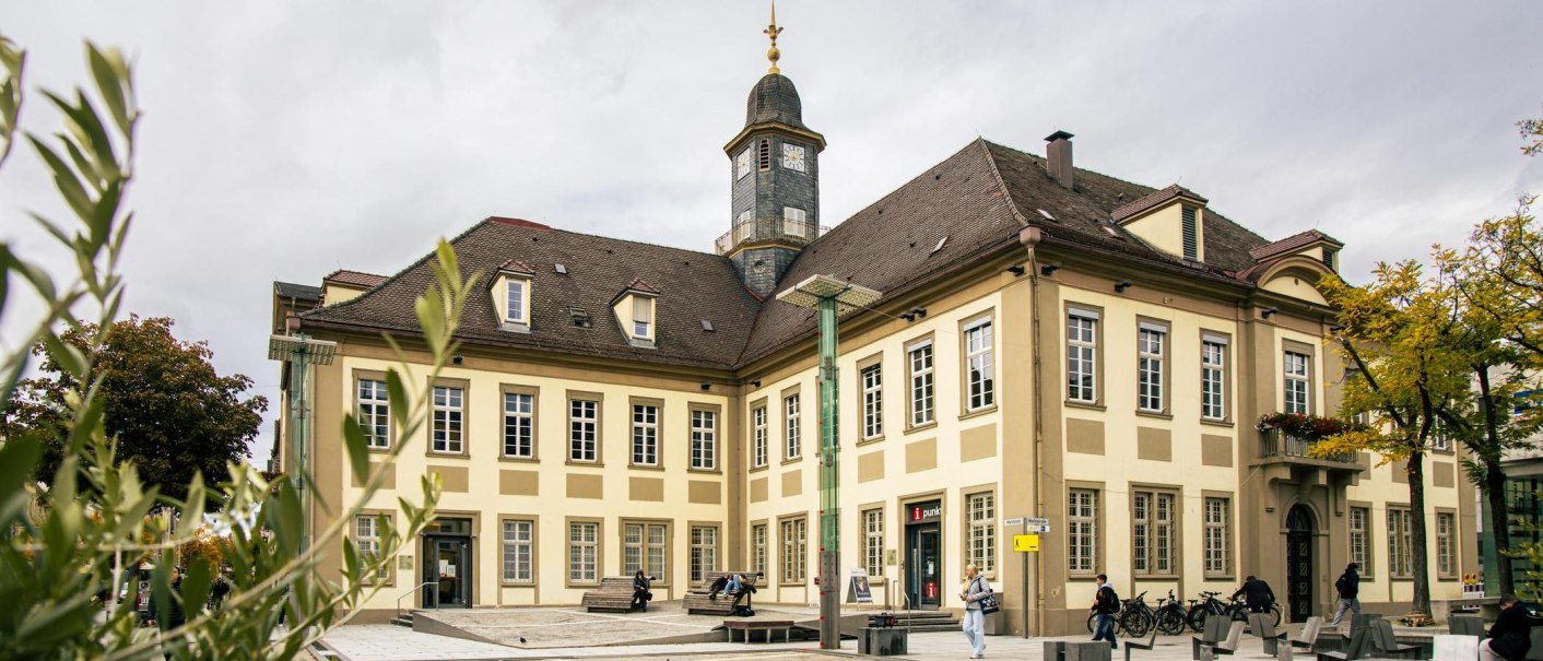 The historic town hall of G&ouml;ppingen on the market square, surrounded by trees and people. The clock tower rises above the building., &copy; SMG Stuttgart Marketing GmbH - Sarah Schmid