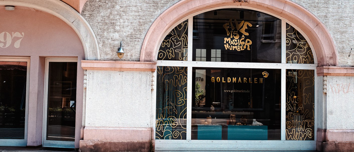 Geb&auml;udefassade mit gro&szlig;en Fenstern, Aufschrift 'Goldmarlen' und dekorativen Elementen. Die Hausnummer 97 ist sichtbar., &copy; Goldmarlen