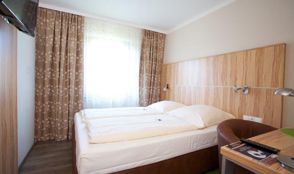 Standard double room with double bed, wooden furniture, TV, desk and curtains. Bright, cozy furnishings., © Hotel Reinhardtshof Garni Standard double room with double bed, wooden furniture, TV, desk and curtains. Bright, cozy furnishings., © Hotel Reinhardtshof Garni