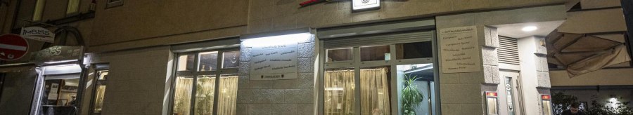 Das Restaurant Brunnenwirt bei Nacht, beleuchtet mit gelbem Schriftzug. Ein Mann steht an einem Tisch vor dem Eingang., &copy; SMG, Sarah Schmid