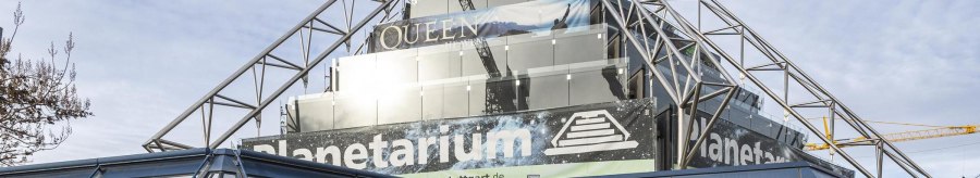 The Carl-Zeiss Planetarium Stuttgart with modern glass and steel architecture, advertising banners and a clear sky in the background., &copy; Stuttgart-Marketing GmbH, Sarah Schmid