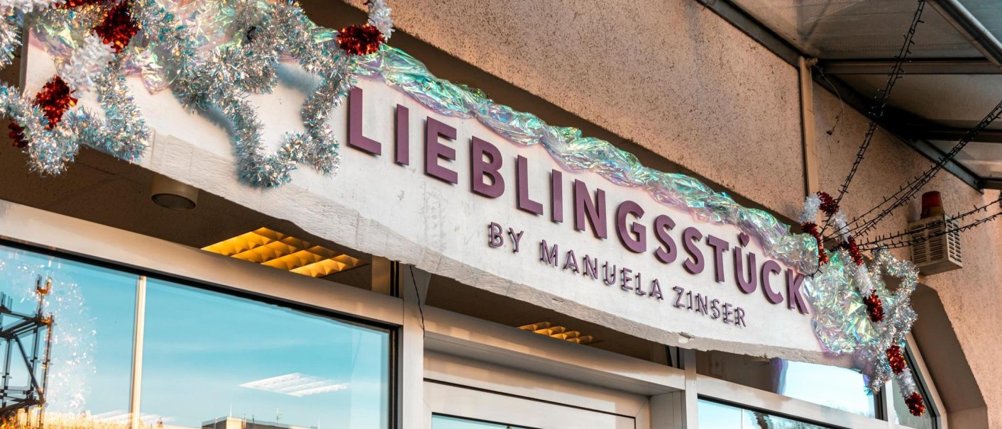 Lettering in red letters on a white background: "Lieblingsst&uuml;ck by Manuela Zinser", two large shop windows are located to the left and right of the entrance door., &copy; SMG Stuttgart Marketing GmbH - Sarah Schmid