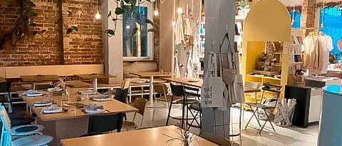 A cozy caf&eacute; with wooden tables, chairs and decorative plants. The brick walls and soft lighting create an inviting atmosphere., &copy; Wyld, Stuttgart