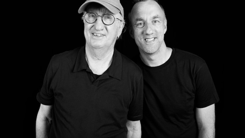 Two men in black clothing against a black background, one wearing a cap and glasses., &copy; Theaterhaus Stuttgart e.V.