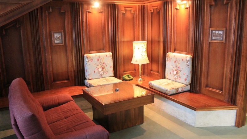 Gemütliche Sitzecke mit Holzwänden, floral gemusterten Kissen, Tisch und Lampe. Ein Telefon steht auf dem Tisch., © Hotel Spahr Gemütliche Sitzecke mit Holzwänden, floral gemusterten Kissen, Tisch und Lampe. Ein Telefon steht auf dem Tisch., © Hotel Spahr