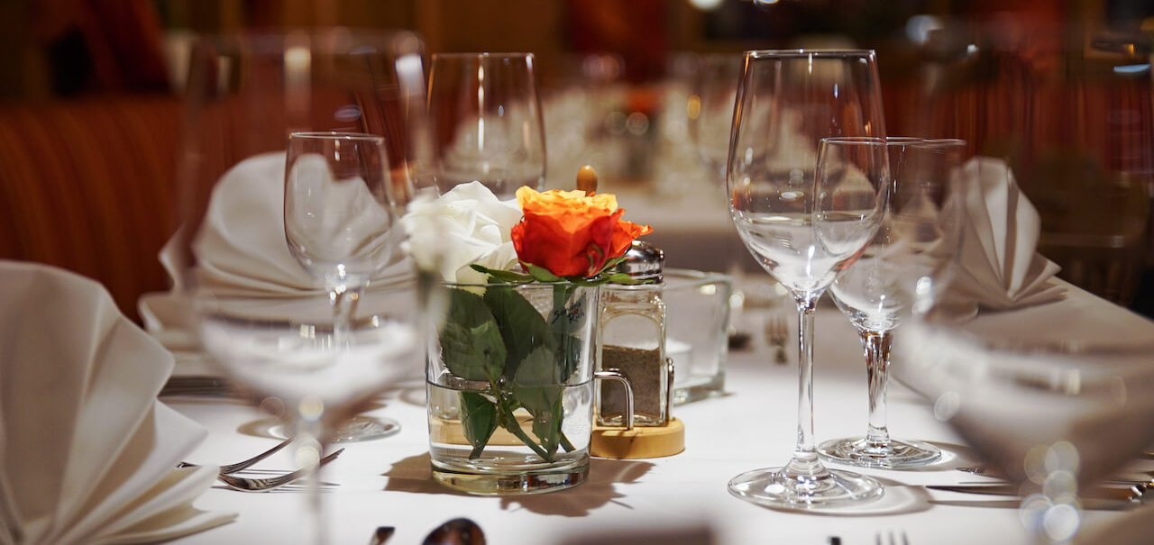 Eleganter Tisch mit Weingläsern, weißen Servietten und einer Vase mit Rosen in einem stilvollen Restaurant., © Hetzel Hotel Stuttgart Eleganter Tisch mit Weingläsern, weißen Servietten und einer Vase mit Rosen in einem stilvollen Restaurant., © Hetzel Hotel Stuttgart