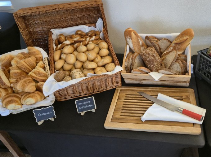A rich breakfast buffet with croissants, rolls and sliced bread. A bread cutting board with knife is ready for guests., &copy; Cool-Tours StattReisen