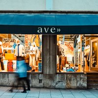 Shop window of a fashion store with graffiti decoration. A person walks past. The store is called 'ave'., &copy; Mario P. Rodrigues
