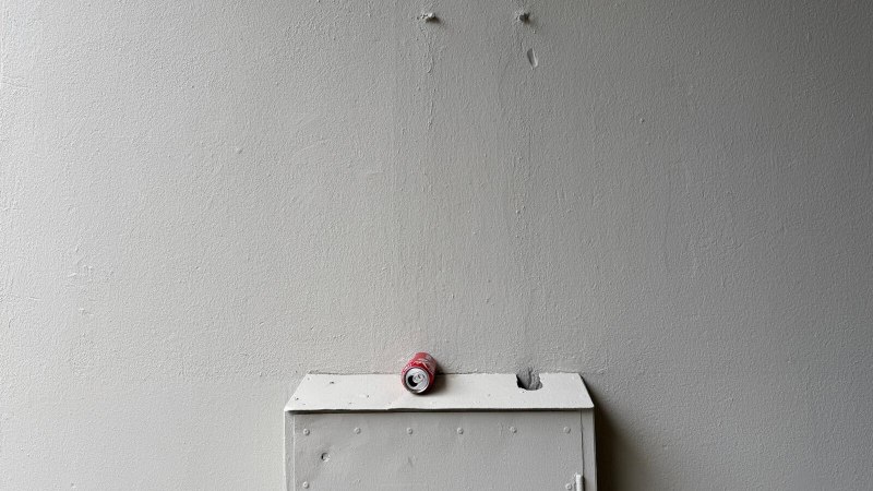 Zerdrückte rote Getränkedose auf weißem Kasten vor grauer Wand., © StadtPalais Zerdrückte rote Getränkedose auf weißem Kasten vor grauer Wand., © StadtPalais