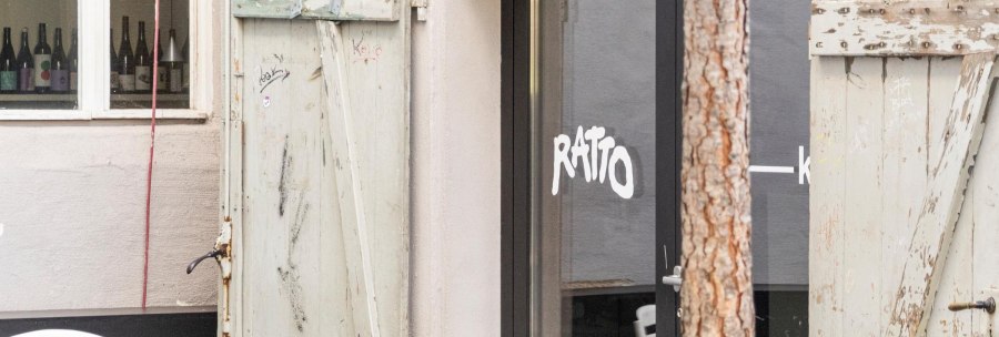 Entrance to the Ratto Bar with glass front and old, weathered wooden doors. Wine bottles can be seen in the window., &copy; Stuttgart-Marketing GmbH, Sarah Schmid