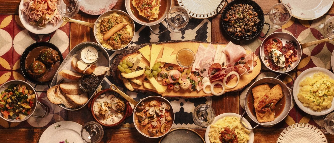 Ein Tisch voller traditioneller deutscher Speisen, darunter Käse, Wurst, Brot, Linsen, Kartoffeln und verschiedene Beilagen., © Gasthaus Bären Stuttgart