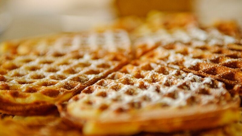 Frisch gebackene belgische Waffeln, mit Puderzucker bestreut, liegen einladend auf einem Teller., &copy; Literaturhaus Stuttgart