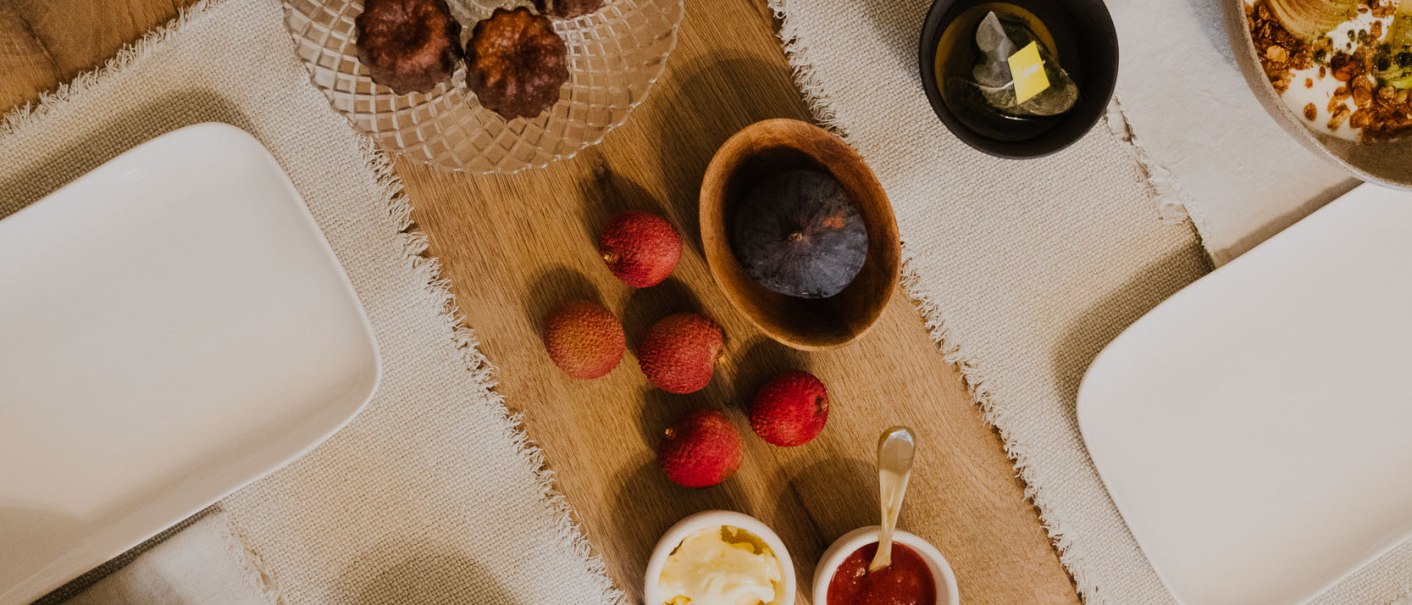 Ein gedeckter Tisch mit Geb&auml;ck, Joghurt mit Beeren, Saft, Tee, Marmelade, Butter und Obst auf Holzuntergrund., &copy; Peter Oliver Wolff / DAS EDITH