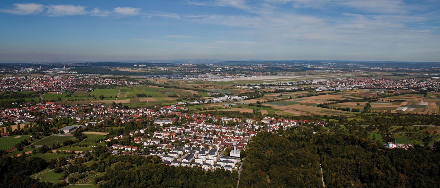Aerial view of Leinfelden-Echterdingen: Residential areas, fields and an airport in the background under a blue sky., © Stuttgart-Marketing GmbH
