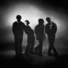 Vier Personen stehen in Silhouette vor einem verschwommenen Hintergrund. Die Szene wirkt geheimnisvoll und k&uuml;nstlerisch., &copy; links im Bild